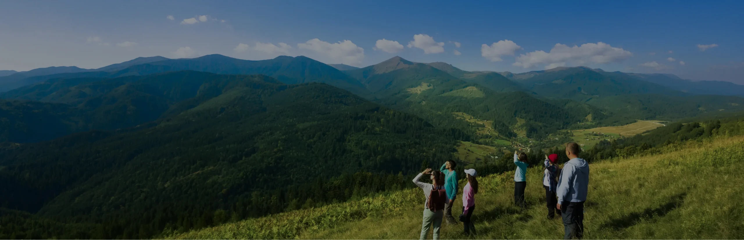 Students trekking across green mountain hills in Southeast Asia